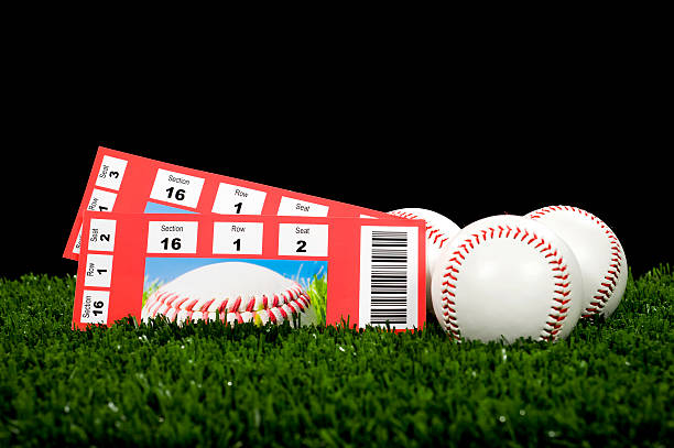 istock Two tickets of baseball games resting on grass with balls 160949052