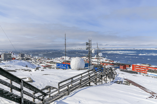 Stairs to the arctic station covered in snow and Nuuk city fjord view, Greenland
