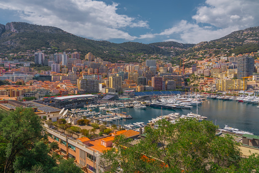 Summer landscape of Monaco. Aerial view. View of Skyline, Hercules Port in Monaco, Monte Carlo. Many luxury yachts and grandstand of Monaco open-wheel single-seater racing car Grand Prix and mountains in the background.