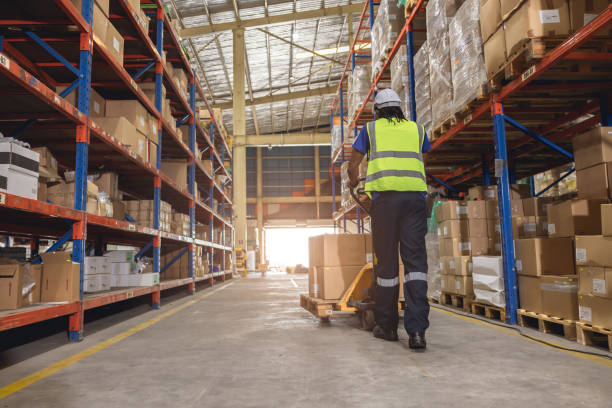 istock warehouse worker using hand pallet trucks loading cargo for shipping logistics depot products from shelf storage 1609534251