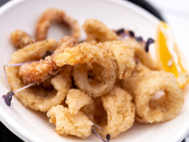 istock Deep fried squid rings served on a paper plate 1609541827