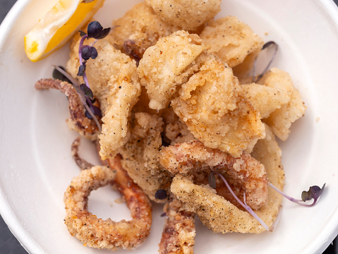 Deep fried squid rings served on a paper plate