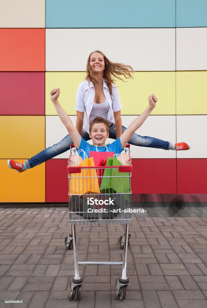 teenage girl and boy en una cesta de compras - Foto de stock de Humor libre de derechos