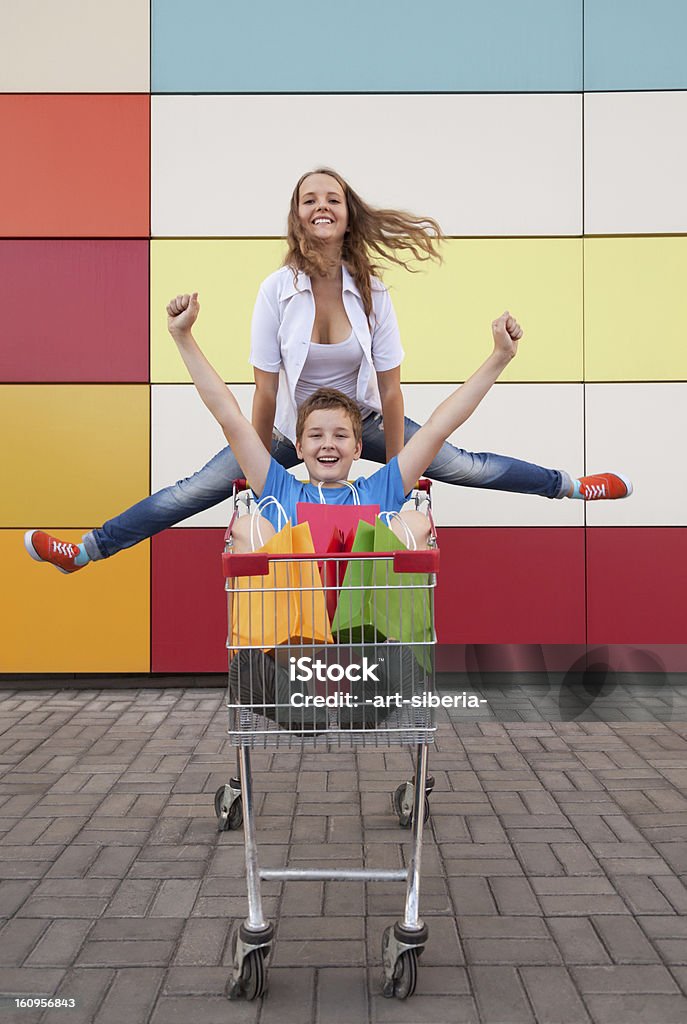 Menina e menino adolescente em um carrinho de compras - Foto de stock de Humor royalty-free