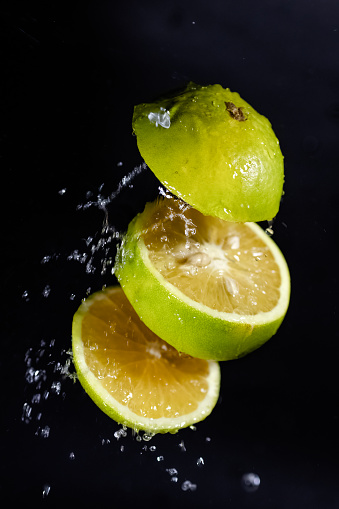 lemon slice falls into the water on a white background