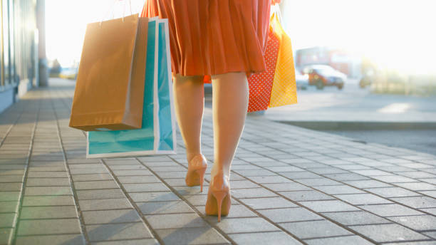 istock Low section woman walking on footpath with shopping bag 1609598158