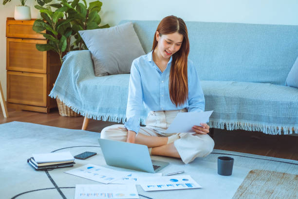 istock Asian young woman working from home using computer and drinking coffee in her room document finance and conference online meeting for new projects 1609598669