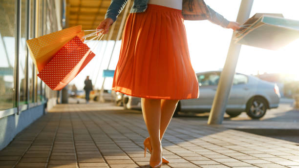 istock Low section woman walking on footpath with shopping bag 1609598670