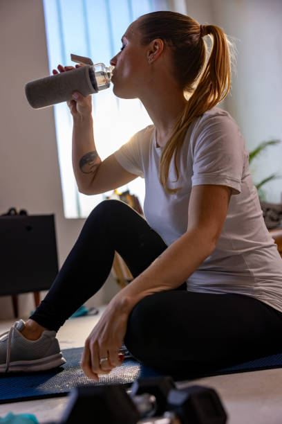 istock Thirsty sportswoman drinking water from bottle 1609604080