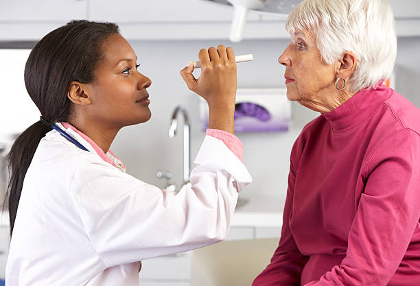 médico examinando os olhos do paciente do sexo feminino idoso - patient happiness cheerful optometrist imagens e fotografias de stock