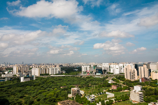 Gurgaon skyline during monsoon. Gurugram,Haryana,India cityscape with modern architecture,urban,commercial and residential apartment buildings.City aerial view,greenery in Delhi NCR business locality.
