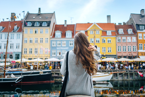 Woman enjoying the view in Nyhavn, one of the famous landmarks of Copenhagen, Denmark
