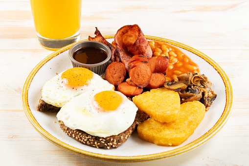 Îreakfast plate with fried eggs, sausages, nuggets and juice. Healthy food concept.