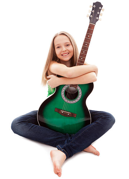 Blonde woman  playing guitar besides a lake