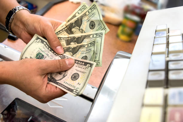Store cashier counting the cash Convenient store female cashier counting the cash at the counter liquor store counter photos stock pictures, royalty-free photos & images