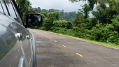 Mirror wing and blurred of beside of grey car.