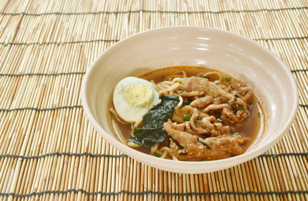 shoyu ramen or Japanese yellow noodles topping slice braised pork and boiled egg  in spicy soy sauce soup