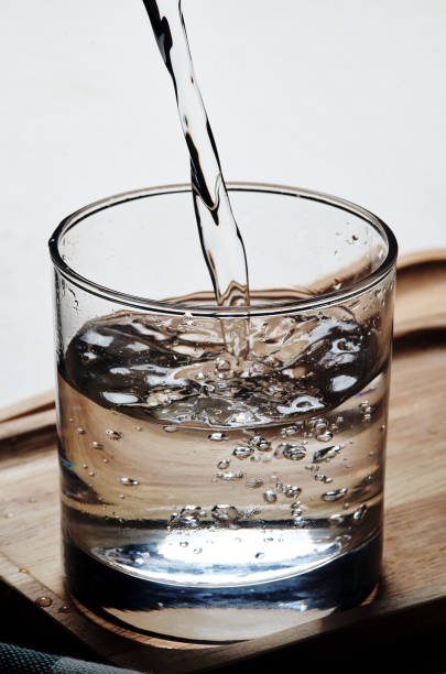 Pouring water into glass stock photo