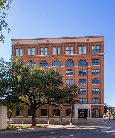 The Texas School Book Depository was a seven-story building located in Dallas, Texas, known for its association with the assassination of President John F. Kennedy. On November 22, 1963, Lee Harvey Oswald fired shots from a sixth-floor window of the building, killing the president as his motorcade passed by.