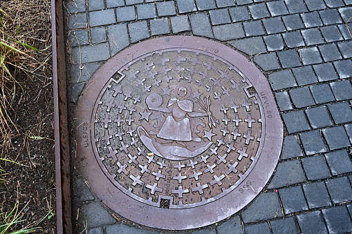 Oslo, Norway, July 3, 2023 - Manhole cover with the city seal of Oslo, Saint Hallvard.