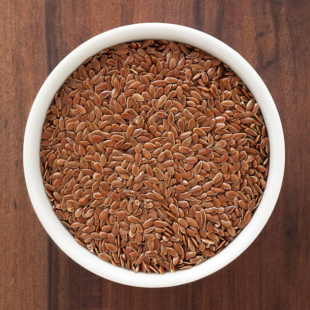 Flax seeds Top view of white bowl full of flax seeds flax seed stock pictures, royalty-free photos & images