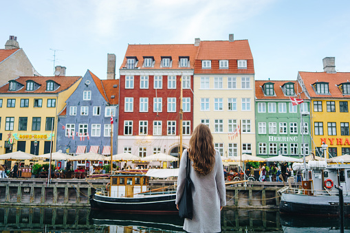 Woman enjoying the view in Nyhavn, one of the famous landmarks of Copenhagen, Denmark