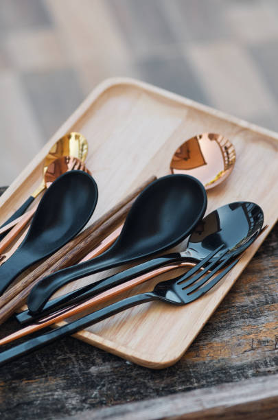 forks and spoons on the wooden tray stock photo