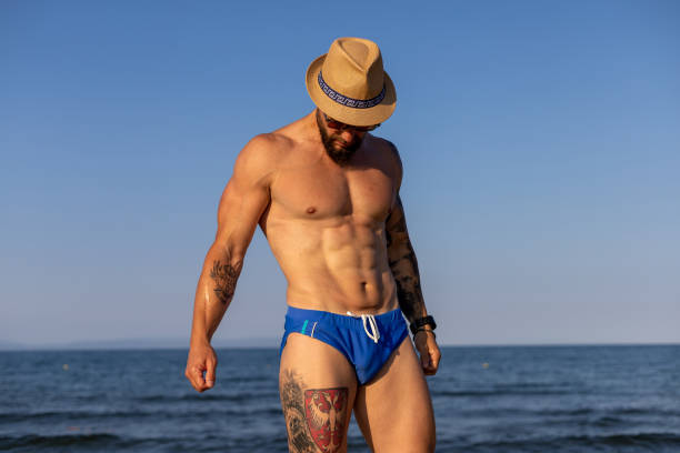 istock Shirtless muscular man at the beach 1609813264