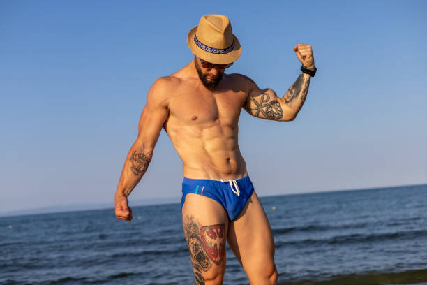istock Shirtless muscular man at the beach 1609813269