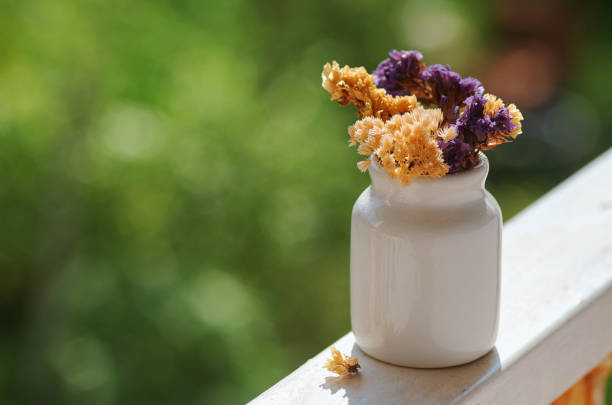Dried flowers in the tiny white ceramic bottle