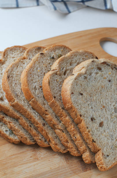 Sliced whole wheat bread on the wooden board stock photo