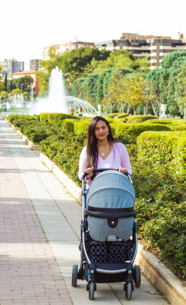 istock Woman walking in a park with gray stroller 1609818119