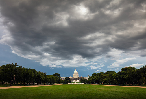 Capitol building in Washington DC with dramatic storm cloud overhead