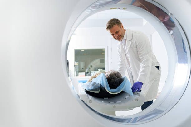 Doctor and female patient in the room of computed tomography at hospital. Healthcare concept Radiologist controls MRI or CT Scan with patient undergoing procedure. High Tech medical equipment doctor head stock pictures, royalty-free photos & images