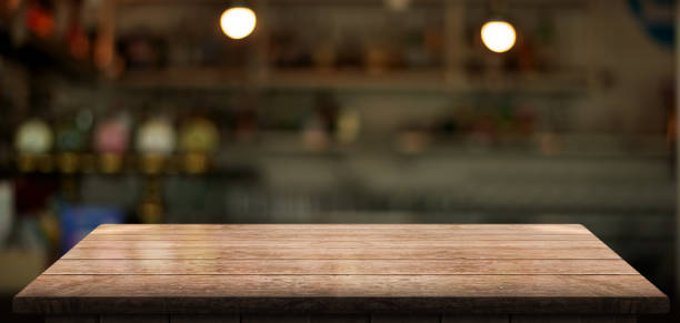 istock Empty wooden table top with lights bokeh on blur restaurant background. 1609871359