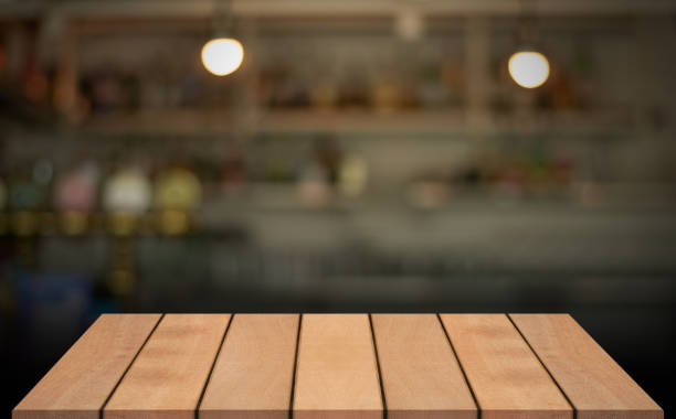 istock Empty wooden table top with lights bokeh on blur restaurant background. 1609871360