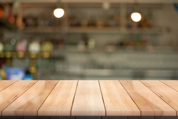 istock Empty wooden table top with lights bokeh on blur restaurant background. 1609871363