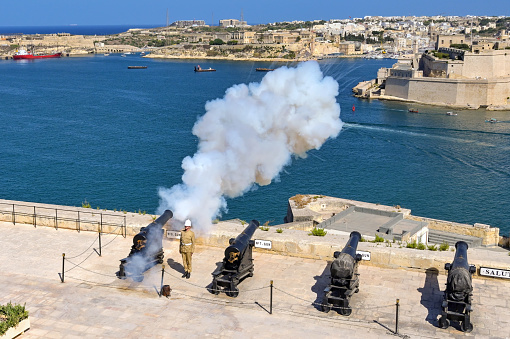 Valletta, Malta - 8 June 2023: Firing of the evening gun salute over the harbour from the top of the city's ancient fortifications
