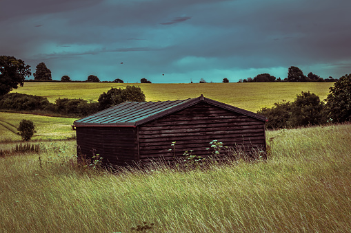 A shed in a field in the English countryside on a moody evening.