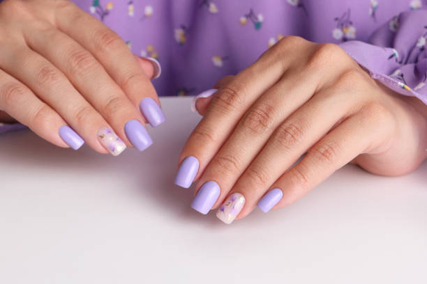 istock Female hands with purple manicure nails 1609915380