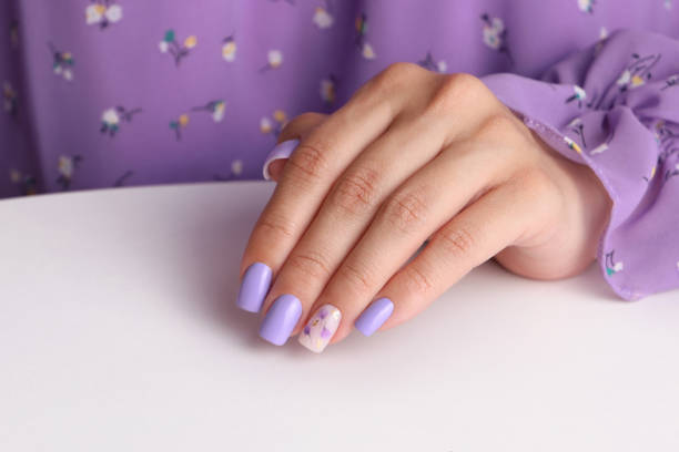 istock Female hand with purple manicure nails 1609916041