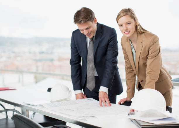 istock Architects reviewing blueprints at desk 160992734