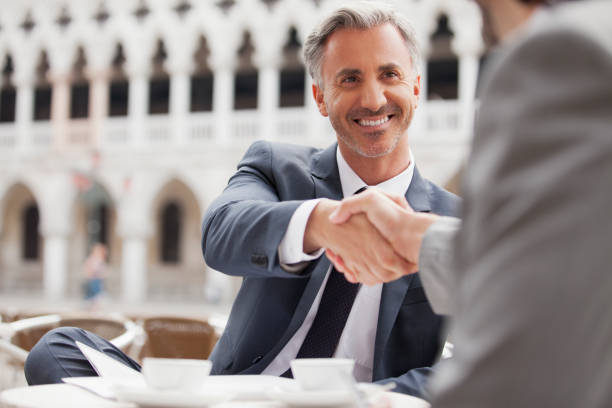 uomini d'affari sorridente stringe la mano al caffè all'aperto - opportunity handshake job business foto e immagini stock