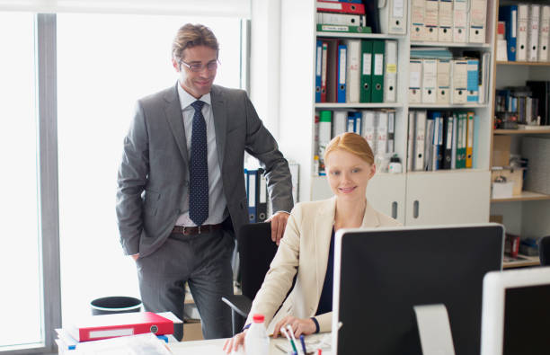 istock Businessman and businesswoman using computer at desk in office 160992905