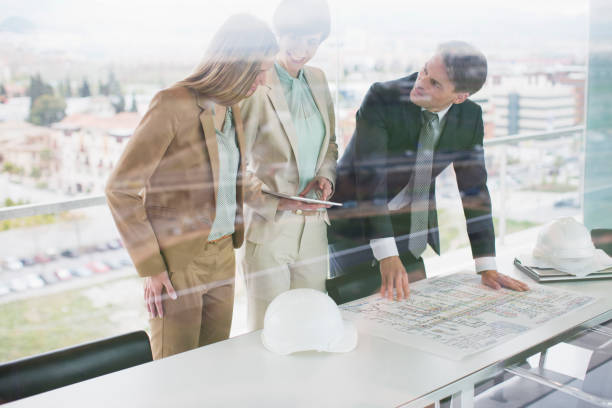 istock Architects with digital tablet reviewing blueprints in office 160992952