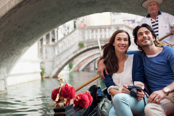 smiling couple riding in gondola in venice - gondola italy venice italy italian culture 뉴스 사진 이미지