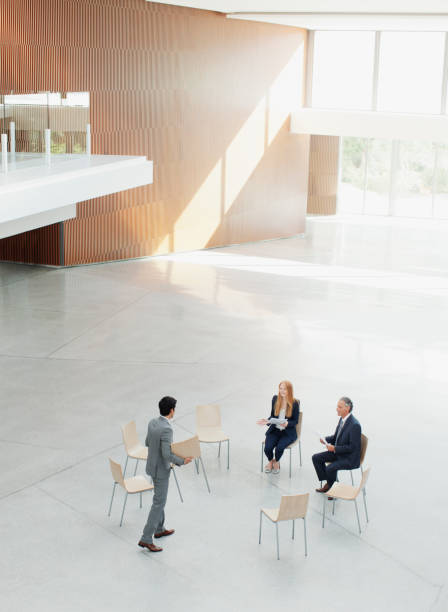 istock Businessman approaching co-workers at circle of chairs 160992988