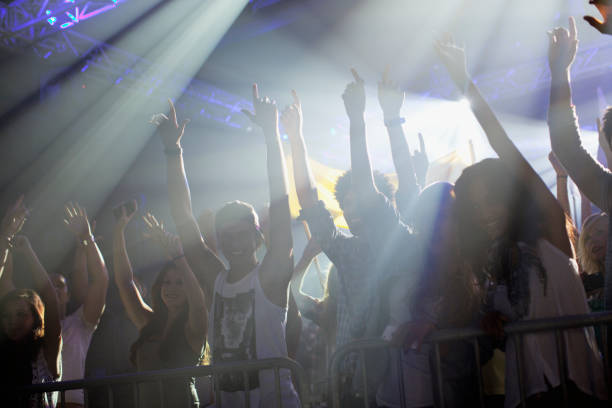 istock Crowd with arms raised behind railing at concert 160993197