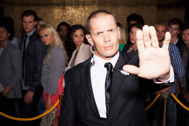 Portrait of bouncer with arm outstretched outside nightclub  roped off stock pictures, royalty-free photos & images