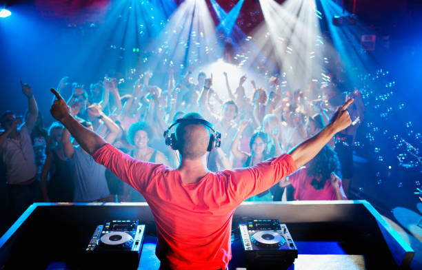 istock DJ with arms outstretched overlooking dance floor 160993275